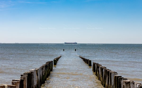 Strandpaaltjes met een schip