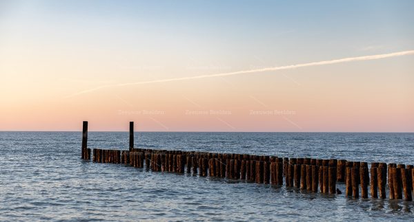 Strandpaaltjes met ondergaande zon
