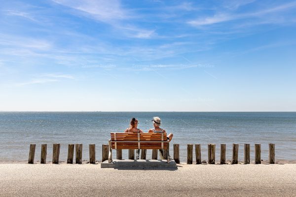 Toeristen op een bankje aan het strand